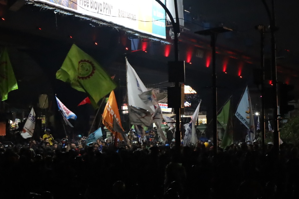 Sempat Diguyur Hujan Deras, Massa Buruh Bekasi Masih Bertahan di Exit Tol Cikarang Barat