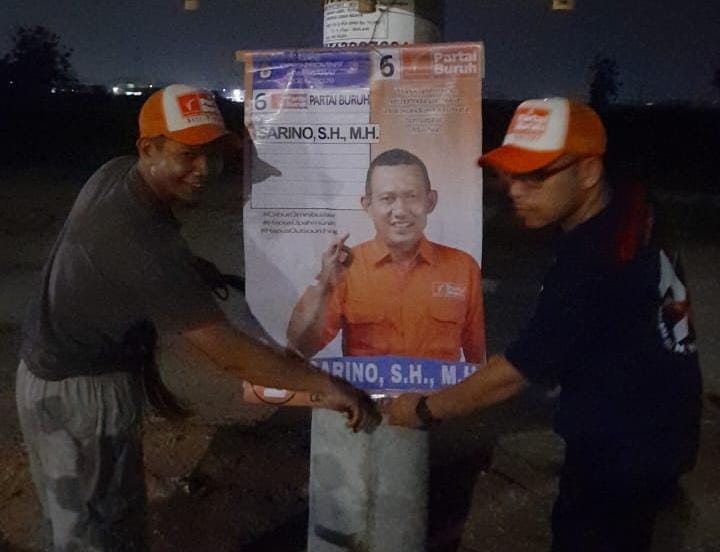 Relawan Partai Buruh Asri Pratama Pasang Banner Caleg Partai Buruh di Jalur Bahkilong